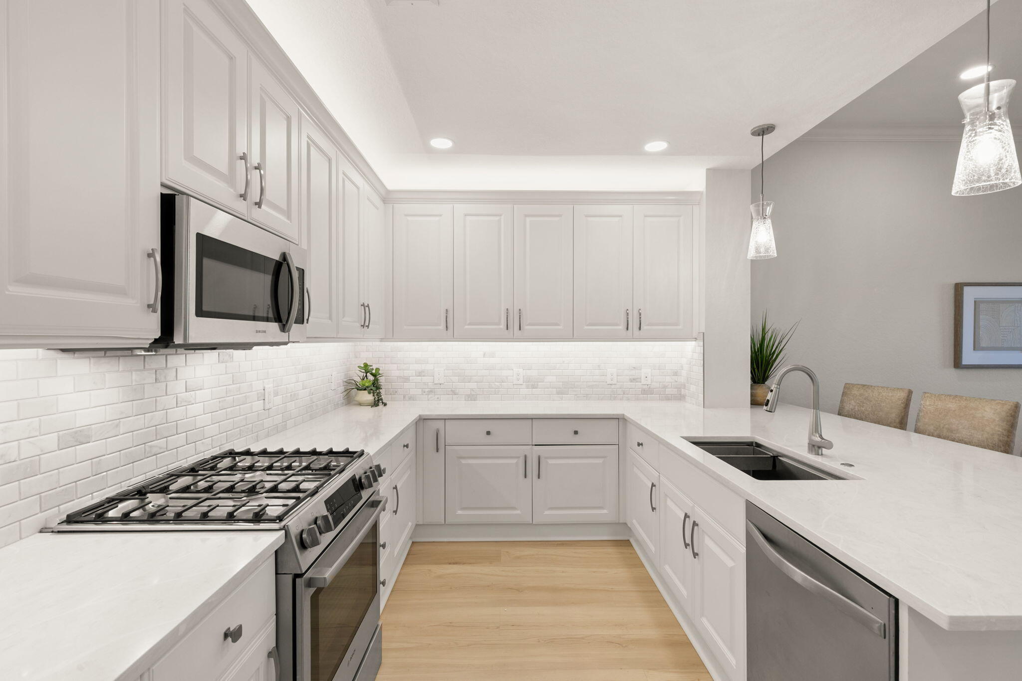 9213 Museo Circle, Unit 103 Naples, FL 34114 - Photo 6 of 47 a kitchen with white cabinets sink and stainless steel appliances