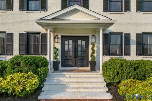 a front view of a house with a lots of potted plants