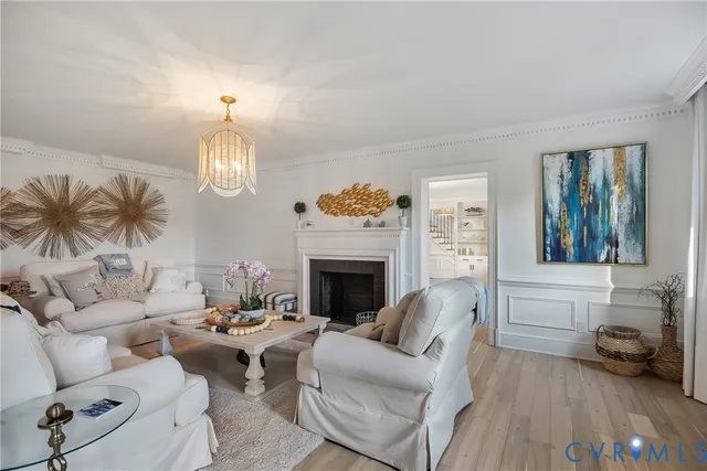 a living room with furniture chandelier and a fireplace