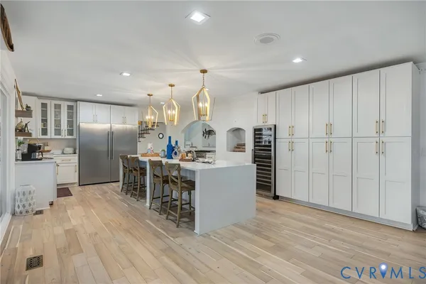 a kitchen with kitchen island a counter top space a sink stainless steel appliances and cabinets