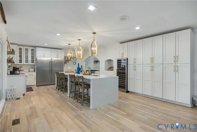 a kitchen with kitchen island a counter top space a sink stainless steel appliances and cabinets