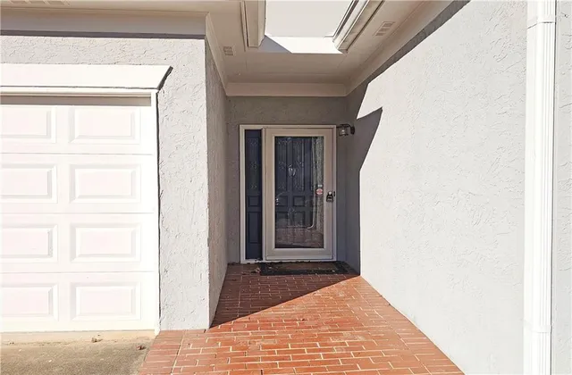 a view of a hallway with wooden floor and a bathroom