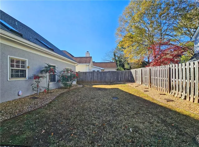 a view of a backyard with wooden fence