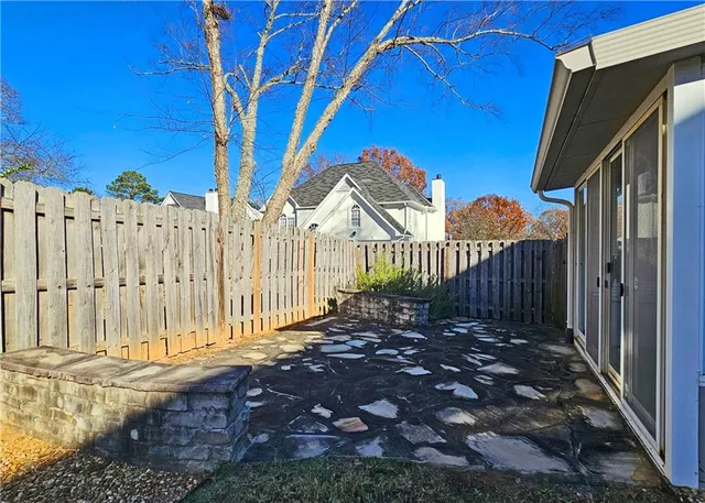 a view of a house with a small yard and wooden fence