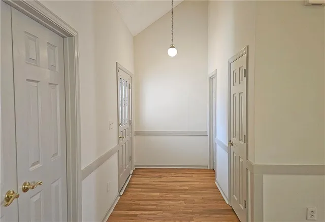 a view of a hallway with wooden floor and a bathroom