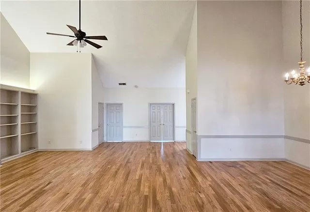 a view of a room with wooden floor and a ceiling fan