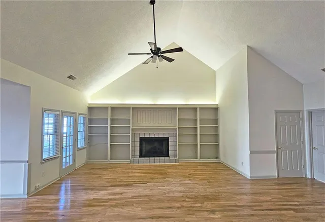 a view of an empty room with a fireplace and a window
