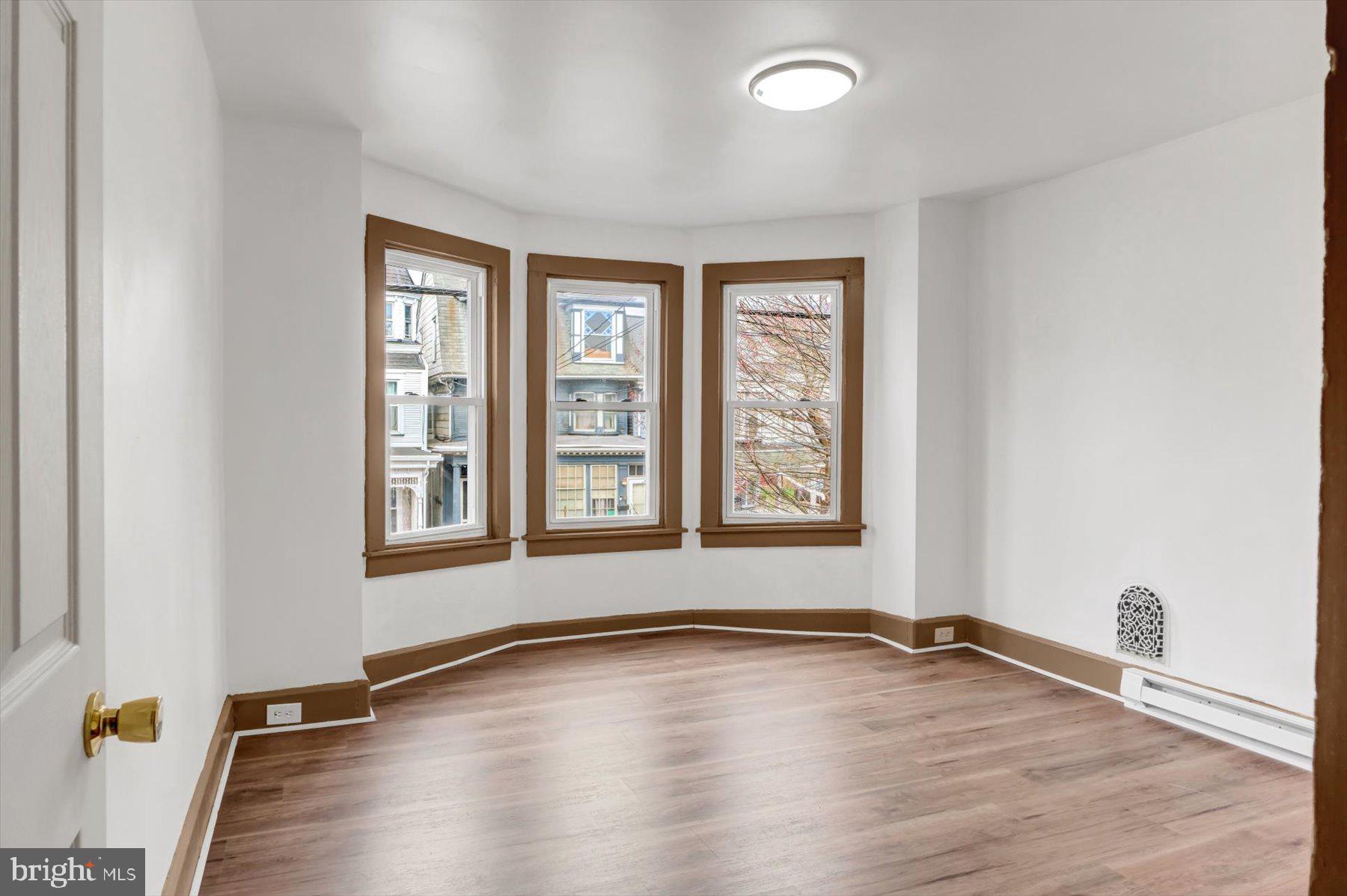 23 North 6th Street Shamokin, PA 17872 - Photo 11 of 27 an empty room with wooden floor and windows