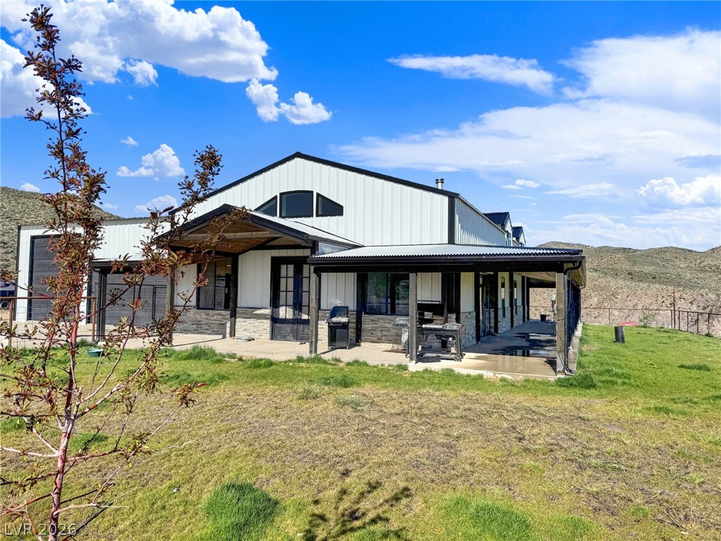 9393 North 93rd Highway Caliente, NV 89008 - Photo 4 of 41 A striking modern farmhouse with expansive covered porches invites outdoor living amidst scenic hill views.