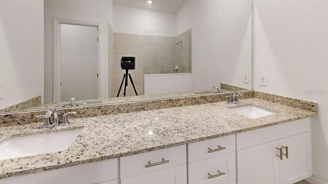 a bathroom with a granite countertop sink and a mirror