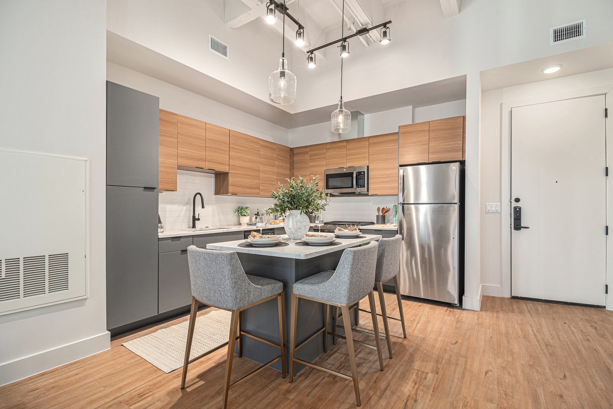 1801 Smith Street, Unit 1701 Houston, TX 77002 - Photo 4 of 25 a kitchen with stainless steel appliances a dining table chairs refrigerator and sink