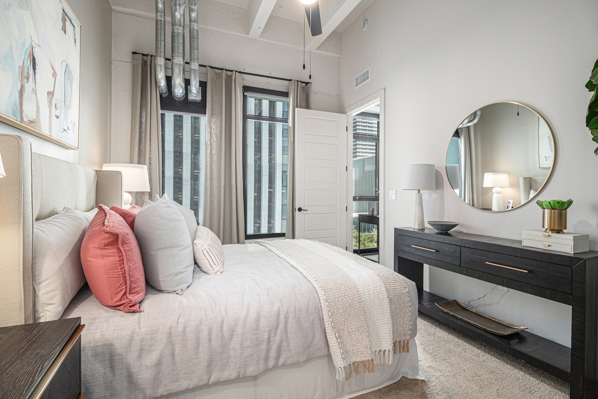 1801 Smith Street, Unit 1701 Houston, TX 77002 - Photo 9 of 25 a bedroom with a bed large mirror and a chandelier