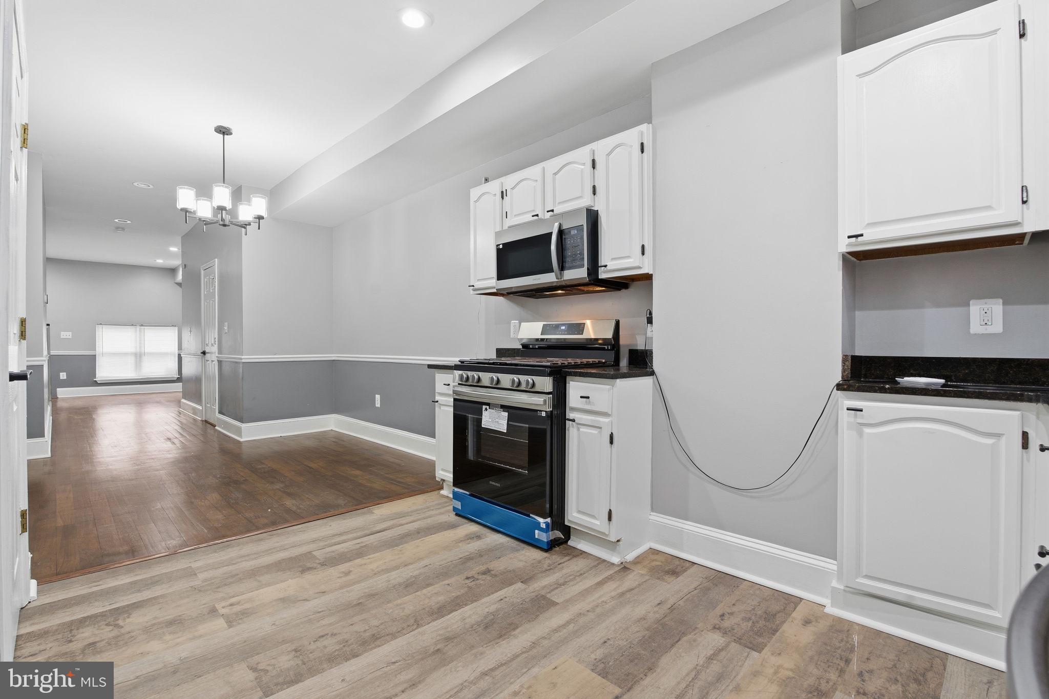 1806 East Lafayette Avenue Baltimore, MD 21213 - Photo 11 of 33 a kitchen with granite countertop a stove top oven a sink a counter space and cabinets