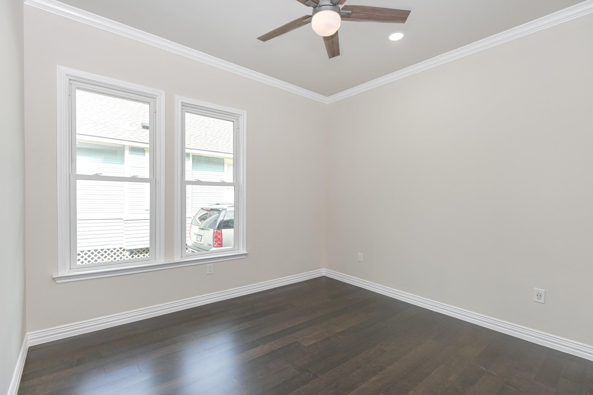 2902 Houston Avenue Houston, TX 77009 - Photo 33 of 42 an empty room with wooden floor chandelier fan and windows