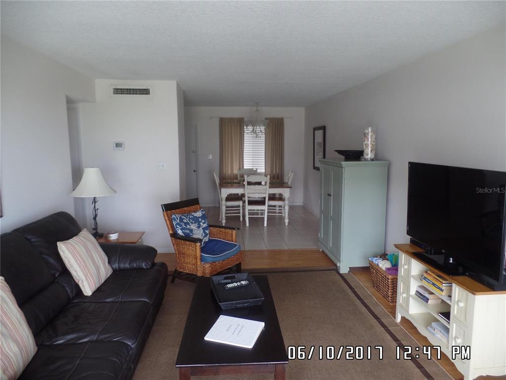 815 Ocean Shore Boulevard, Unit 11 Ormond Beach, FL 32176 - Photo 12 of 15 a living room with furniture and a flat screen tv