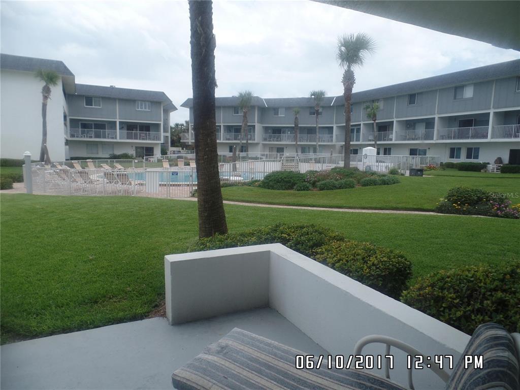 815 Ocean Shore Boulevard, Unit 11 Ormond Beach, FL 32176 - Photo 15 of 15 a view of a big building with a big yard and potted plants