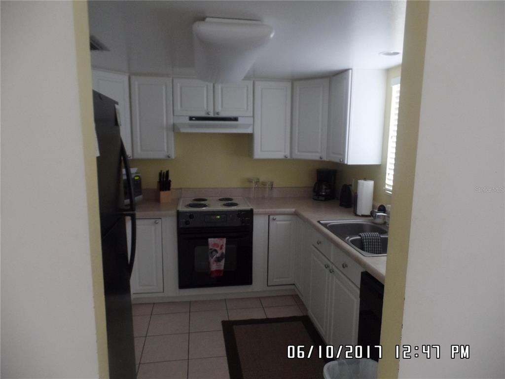 815 Ocean Shore Boulevard, Unit 11 Ormond Beach, FL 32176 - Photo 7 of 15 a kitchen with a stove and a refrigerator