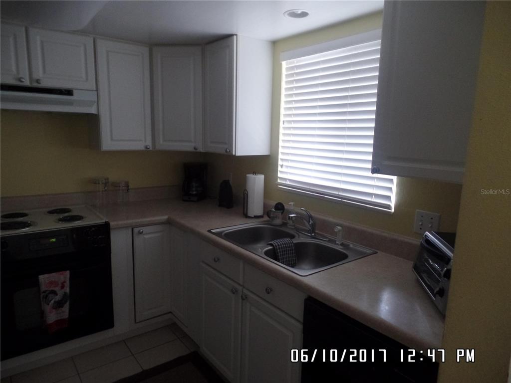 815 Ocean Shore Boulevard, Unit 11 Ormond Beach, FL 32176 - Photo 8 of 15 a kitchen with a sink cabinets and window