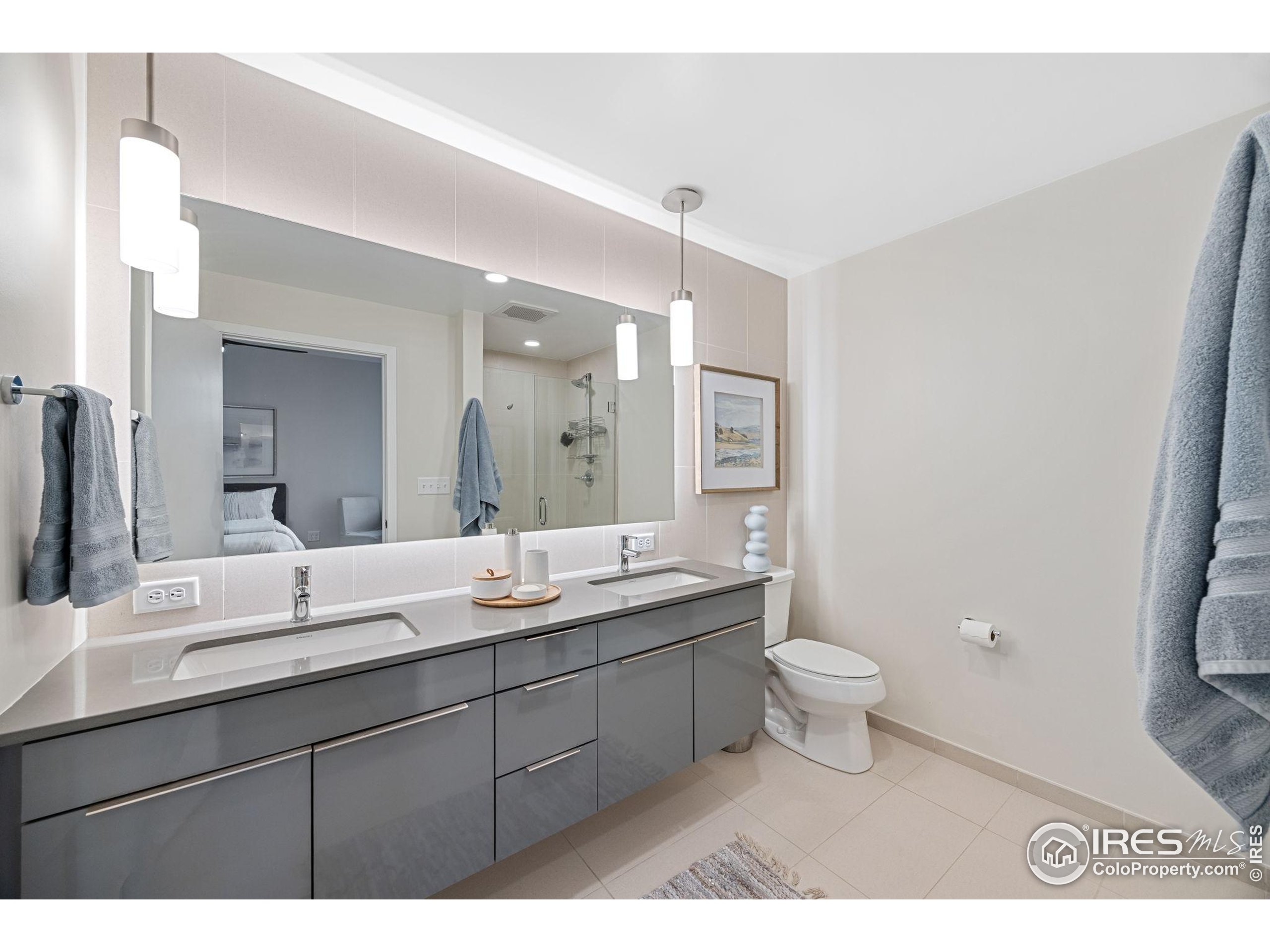 401 Linden Street, Unit 307 Fort Collins, CO 80524 - Photo 25 of 47 a bathroom with a double vanity sink a toilet and a mirror