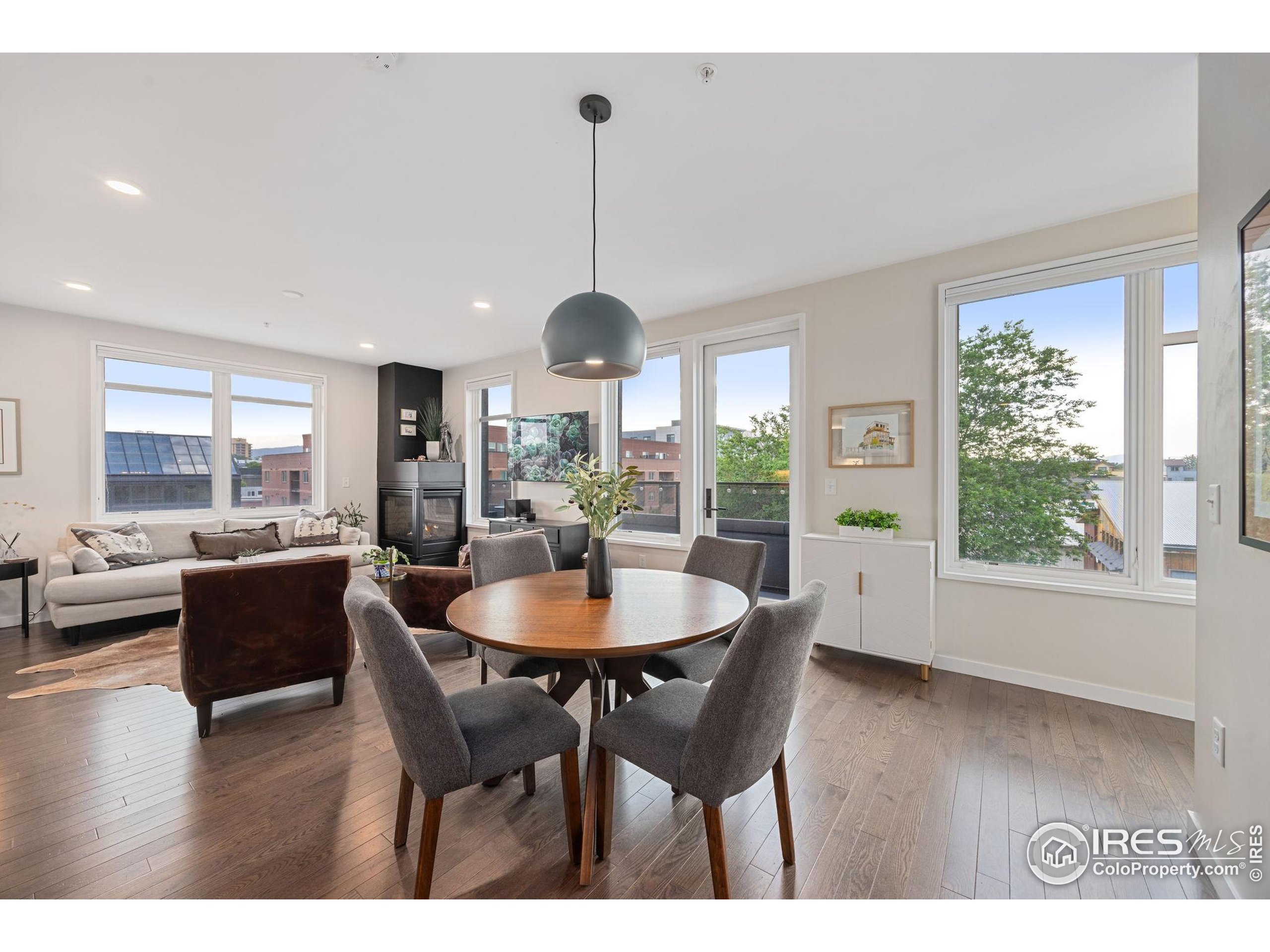 401 Linden Street, Unit 307 Fort Collins, CO 80524 - Photo 6 of 47 a dining room with wooden floor a chandelier a wooden table and chairs