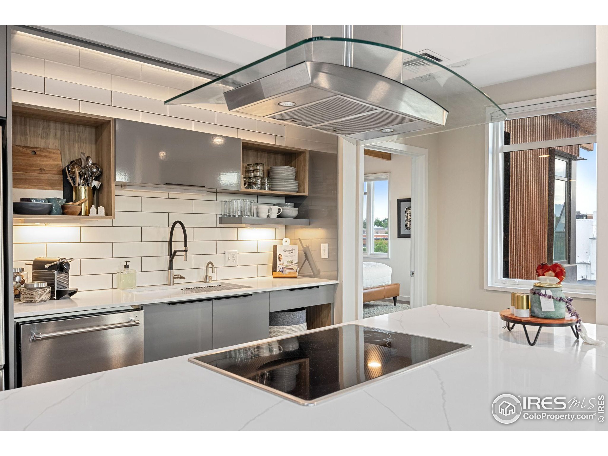 401 Linden Street, Unit 307 Fort Collins, CO 80524 - Photo 9 of 47 a kitchen with stainless steel appliances kitchen island granite countertop a sink and refrigerator