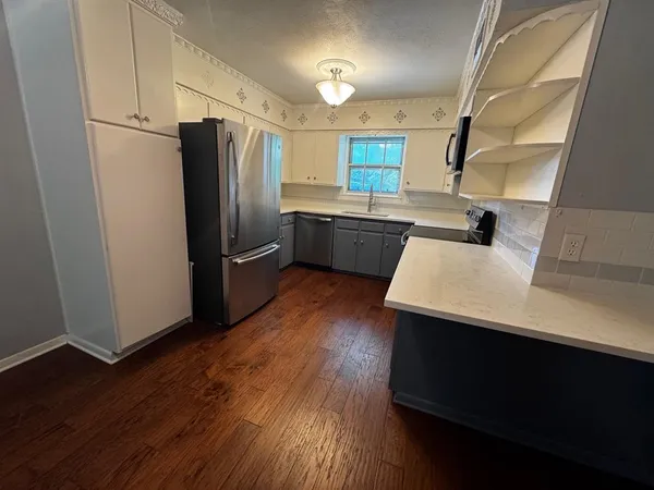 a kitchen with a refrigerator sink and wooden floor