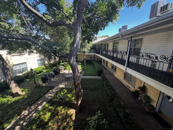 a view of a house with backyard and trees
