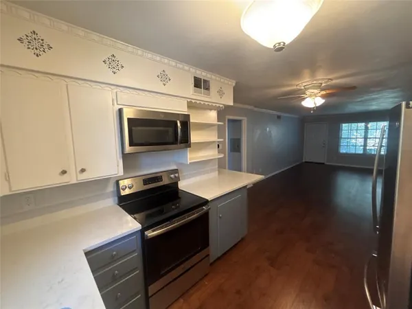 a kitchen with stainless steel appliances a stove microwave and sink
