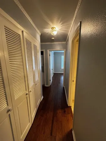 a view of a hallway with wooden floor and staircase