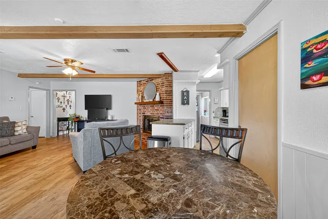 a living room with furniture a flat screen tv and kitchen view