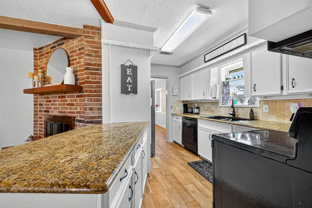 a kitchen with stainless steel appliances granite countertop a stove refrigerator sink and cabinets