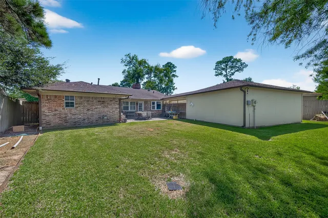 a view of a house with a backyard and a tree