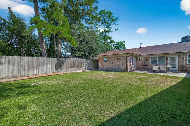a view of a house with a backyard and a patio