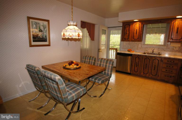 9504 Dundawan Road Nottingham, MD 21236 - Photo 13 of 30 a kitchen with a table chairs and a refrigerator