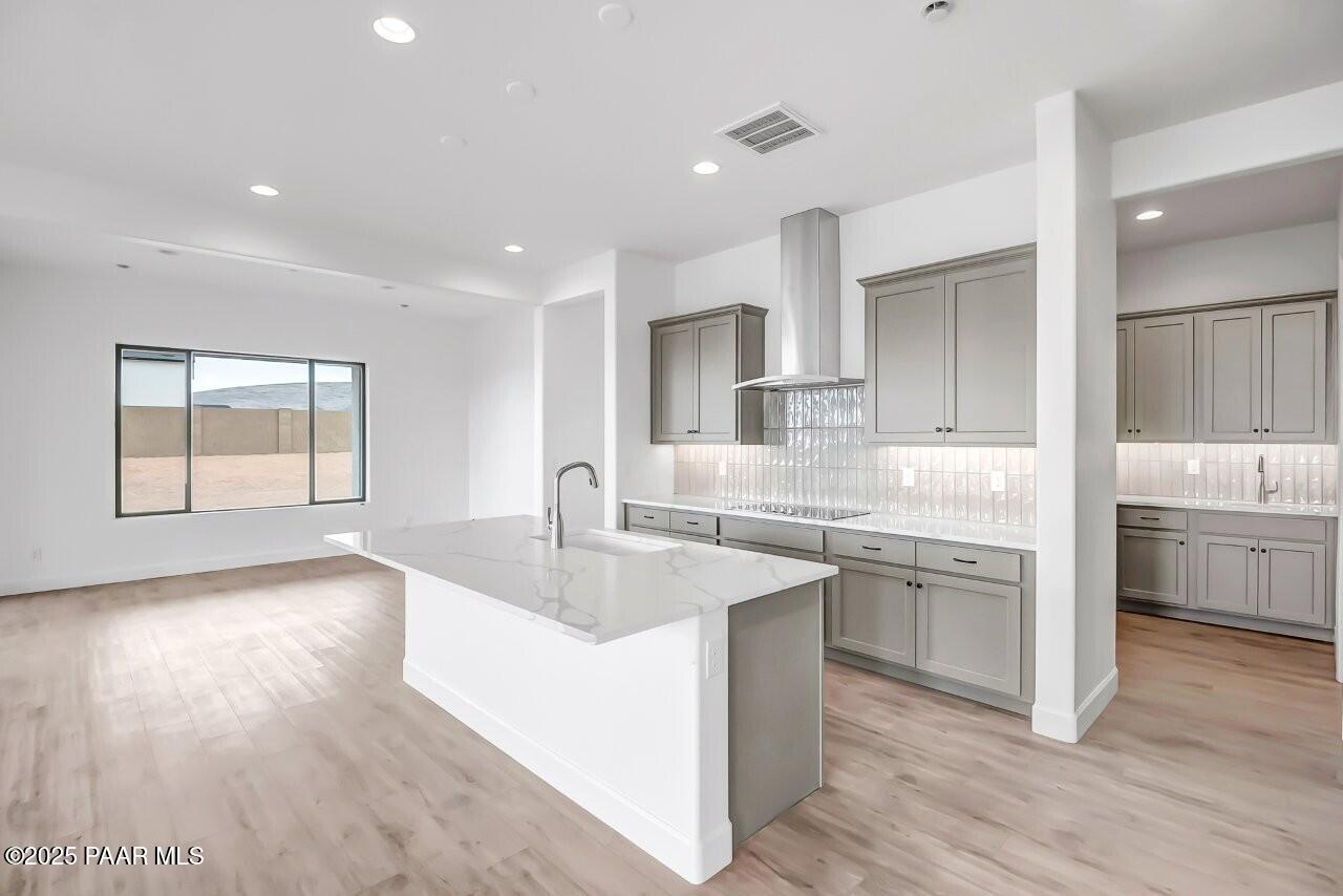 5229 Iron Vine Trail Prescott, AZ 86301 - Photo 4 of 92 a large kitchen with kitchen island a sink dishwasher a stove and a dining table with wooden floor