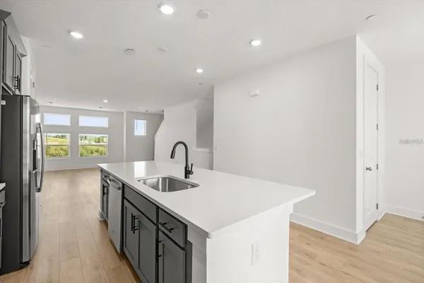 a kitchen that has a sink and a wooden floor
