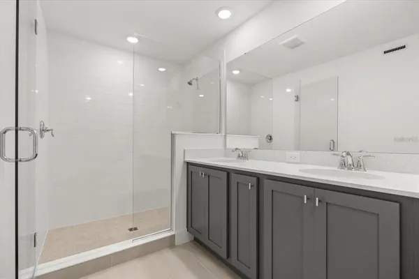 a bathroom with double sink and a mirror