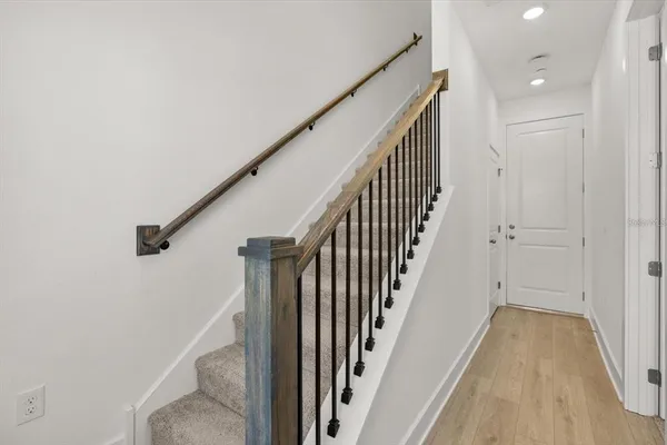 a view of a hallway with wooden floor and staircase