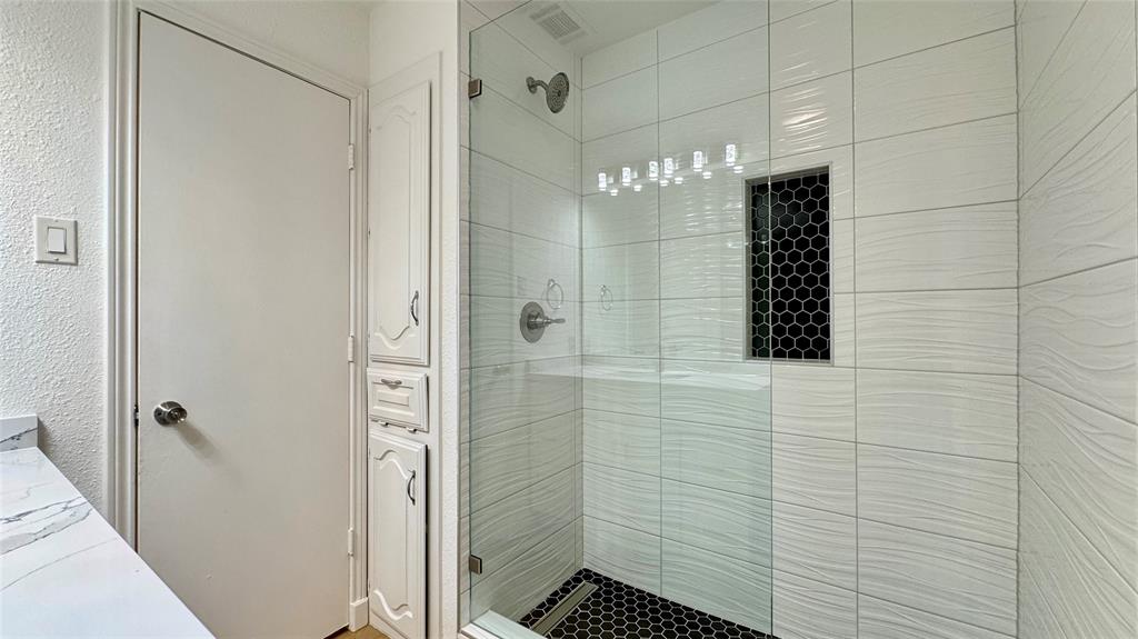 3915 Spring Hollow Drive Carrollton, TX 75007 - Photo 19 of 28 a bathroom with a shower and a sink