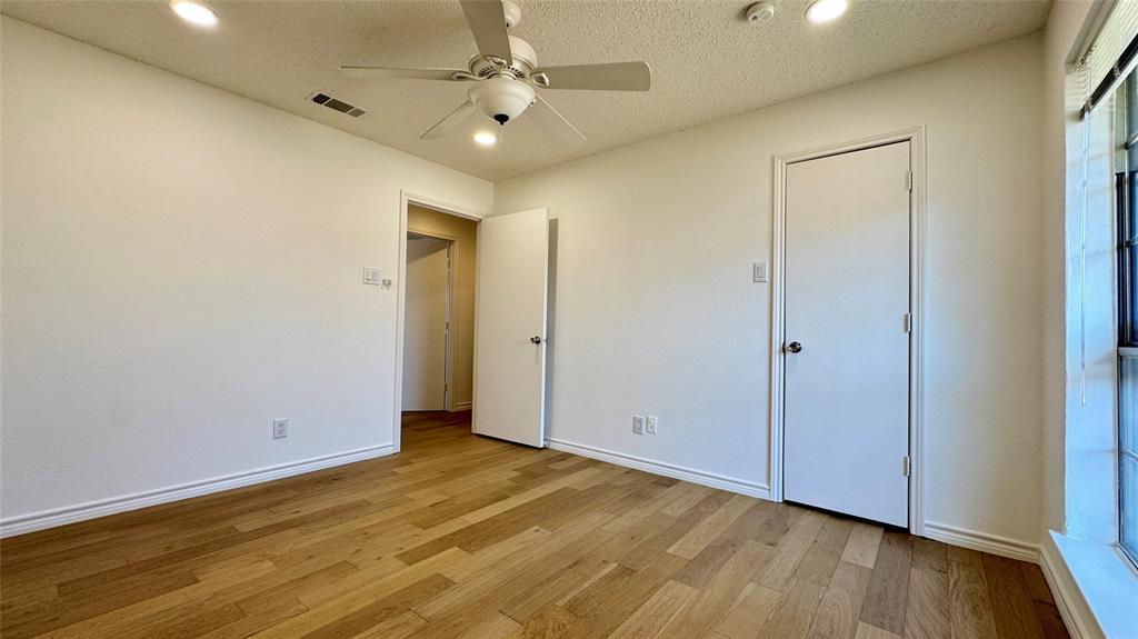 3915 Spring Hollow Drive Carrollton, TX 75007 - Photo 26 of 28 an empty room with wooden floor and a ceiling fan