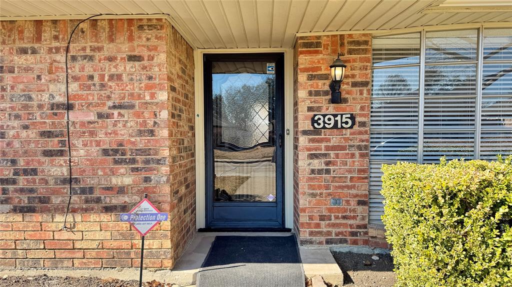 3915 Spring Hollow Drive Carrollton, TX 75007 - Photo 3 of 28 a brick building with a door and a window