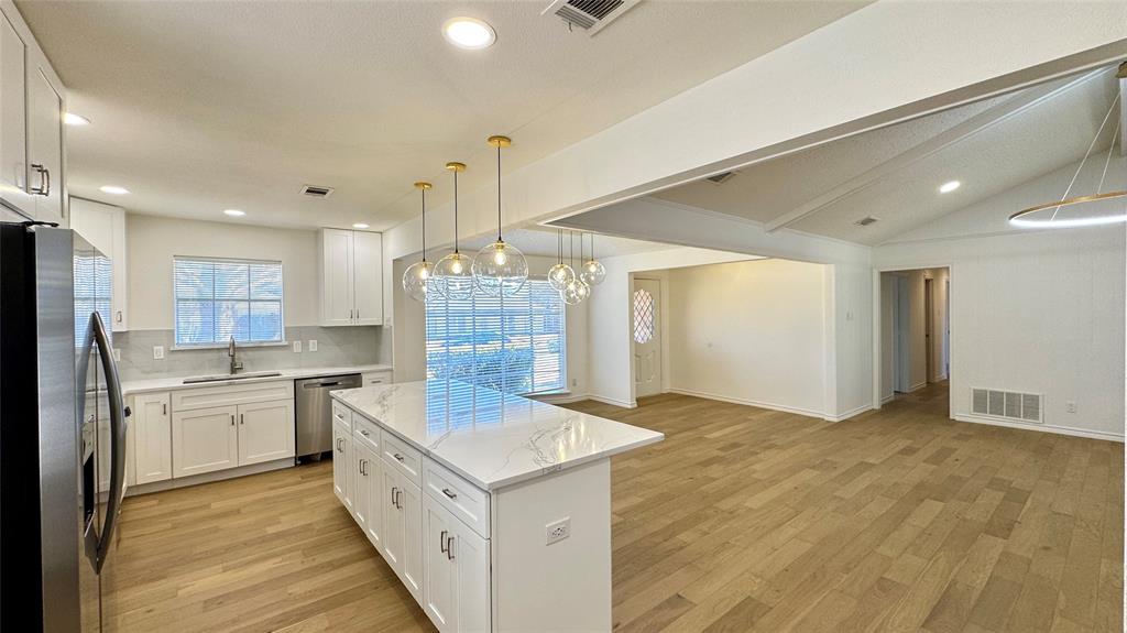 3915 Spring Hollow Drive Carrollton, TX 75007 - Photo 6 of 28 a large kitchen with stainless steel appliances granite countertop a lot of counter space and wooden floors