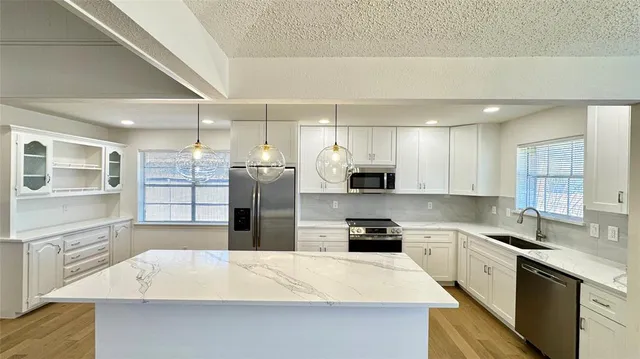 a large kitchen with a large counter top appliances and cabinets