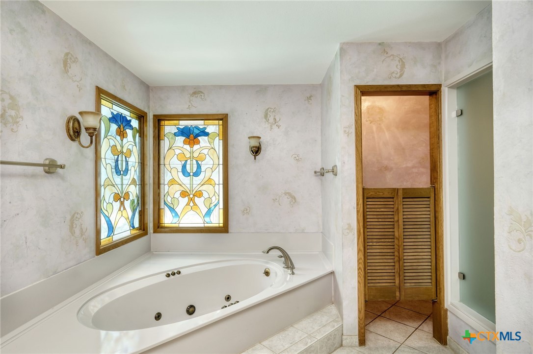 700 Breakaway Road Cedar Park, TX 78613 - Photo 12 of 38 a bathroom with a bathtub and a shower
