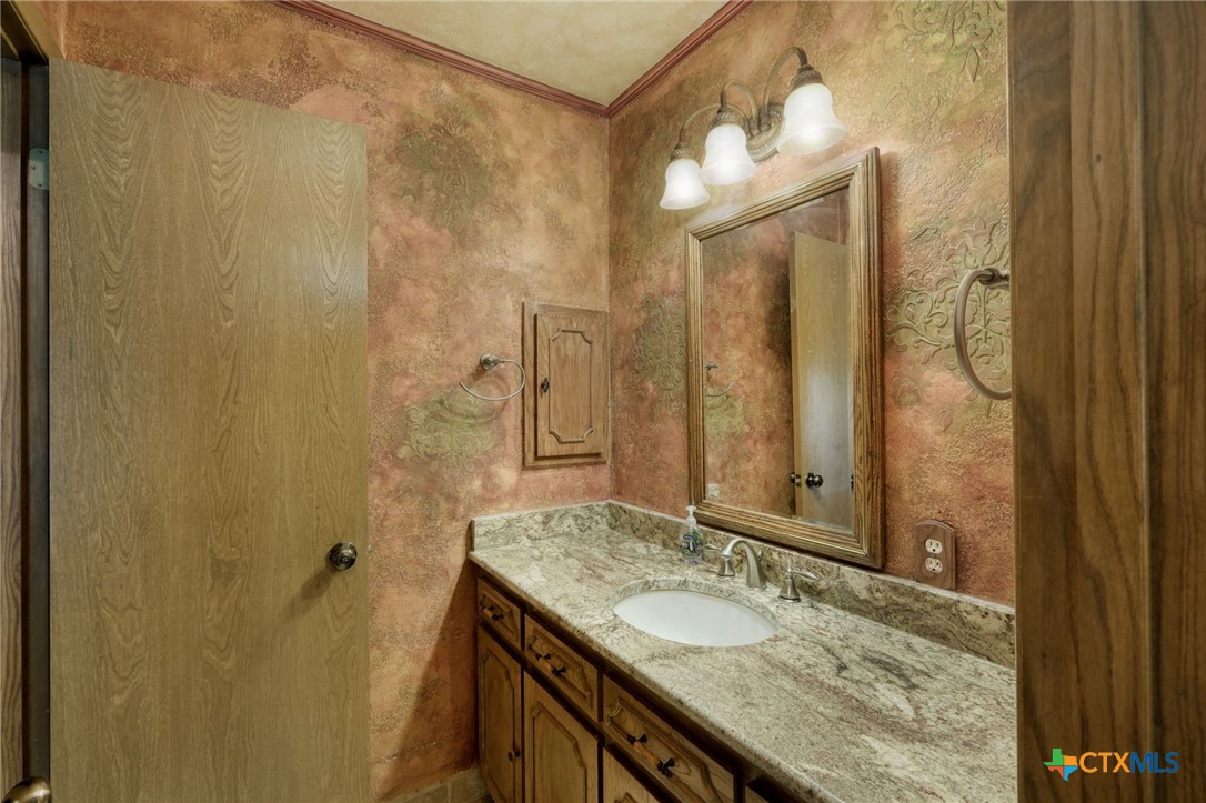 700 Breakaway Road Cedar Park, TX 78613 - Photo 16 of 38 a bathroom with a granite countertop sink and a mirror