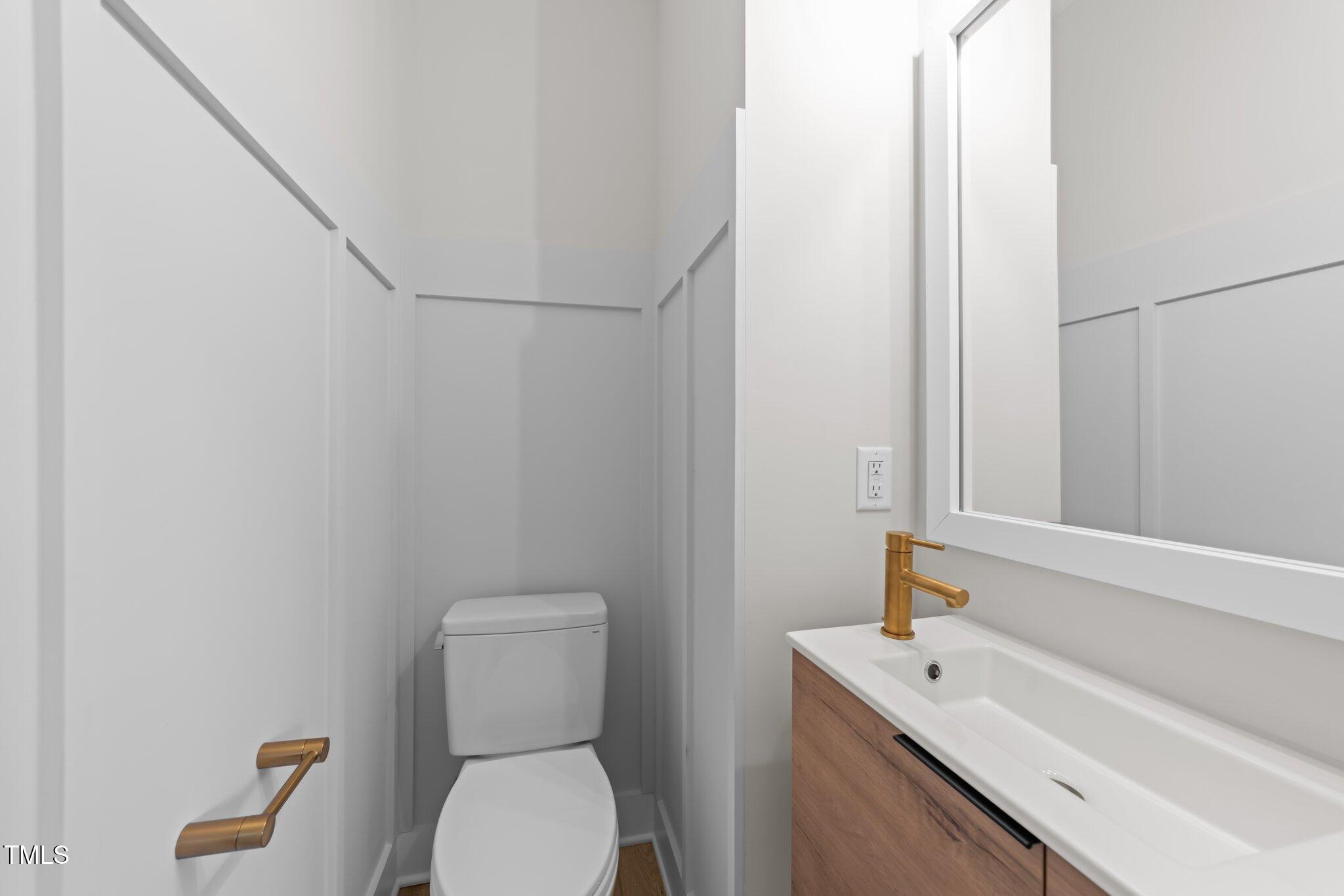 710 West North Street, Unit 101 Raleigh, NC 27603 - Photo 12 of 28 a bathroom with a toilet sink and mirror