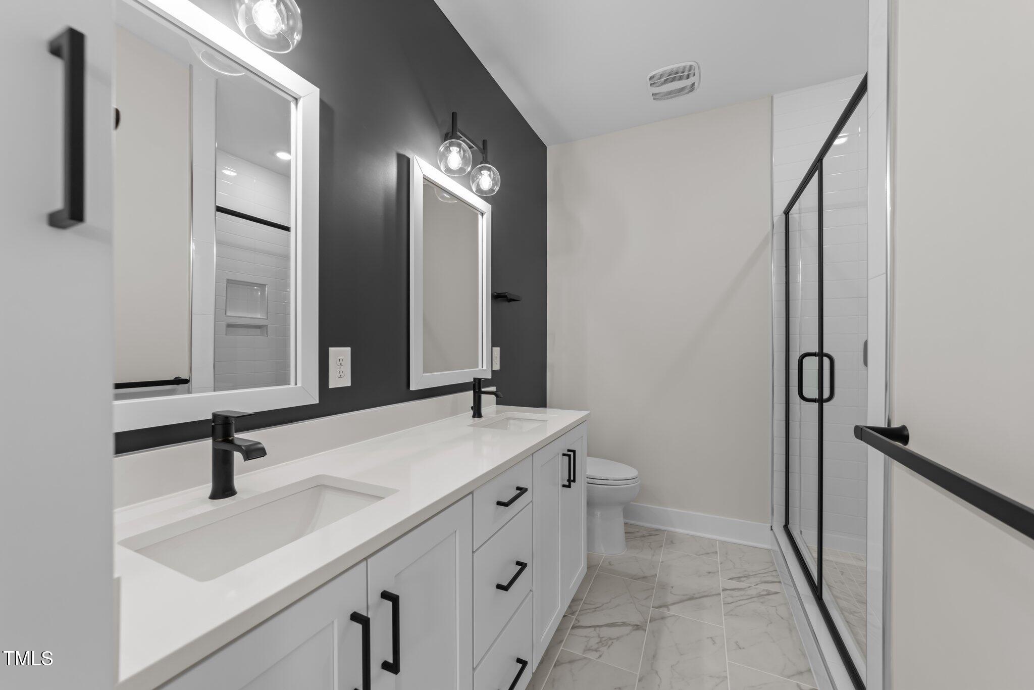 710 West North Street, Unit 101 Raleigh, NC 27603 - Photo 18 of 28 a bathroom with a double vanity sink mirror and toilet