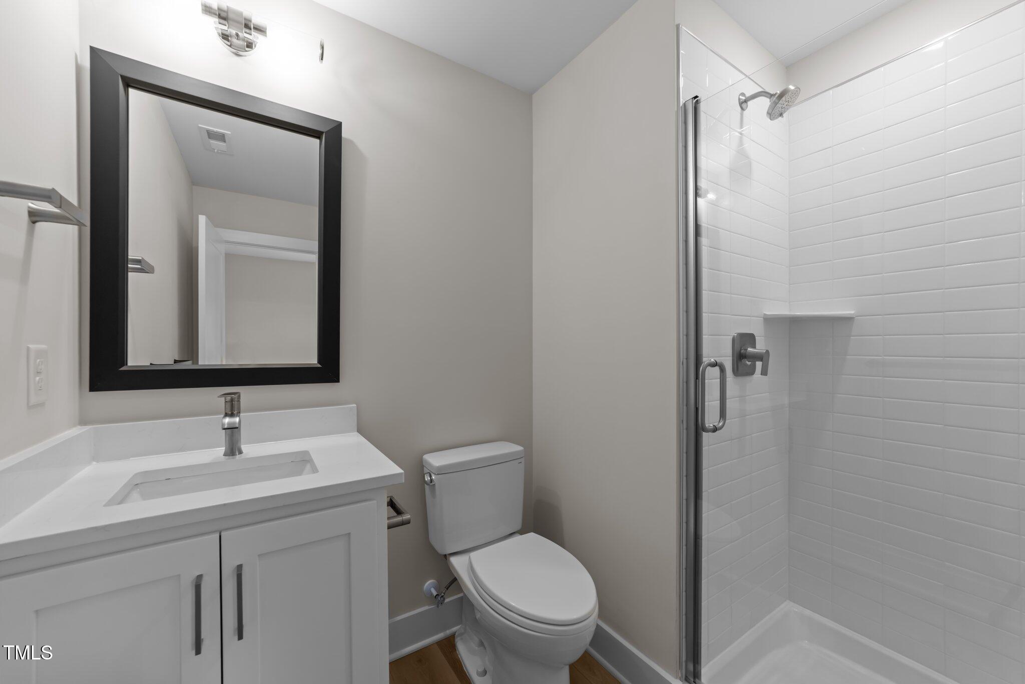 710 West North Street, Unit 101 Raleigh, NC 27603 - Photo 25 of 28 a bathroom with a toilet sink vanity and mirror