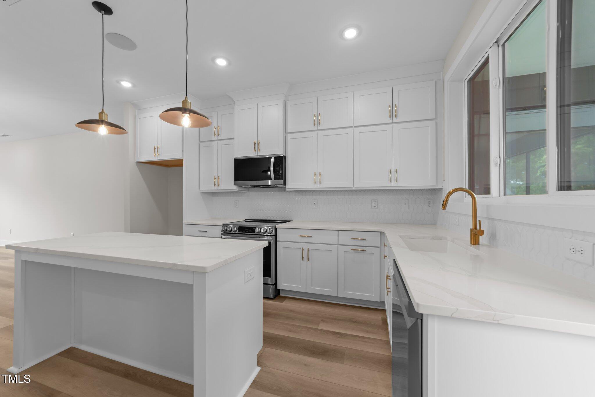 710 West North Street, Unit 101 Raleigh, NC 27603 - Photo 10 of 28 a kitchen with stainless steel appliances granite countertop a sink a stove and a refrigerator