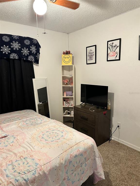 242 Durango Loop Street Davenport, FL 33897 - Photo 18 of 30 a bedroom with a bed and a flat screen tv